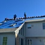 Men on a roof with Roof monster logod roofing Barrier.