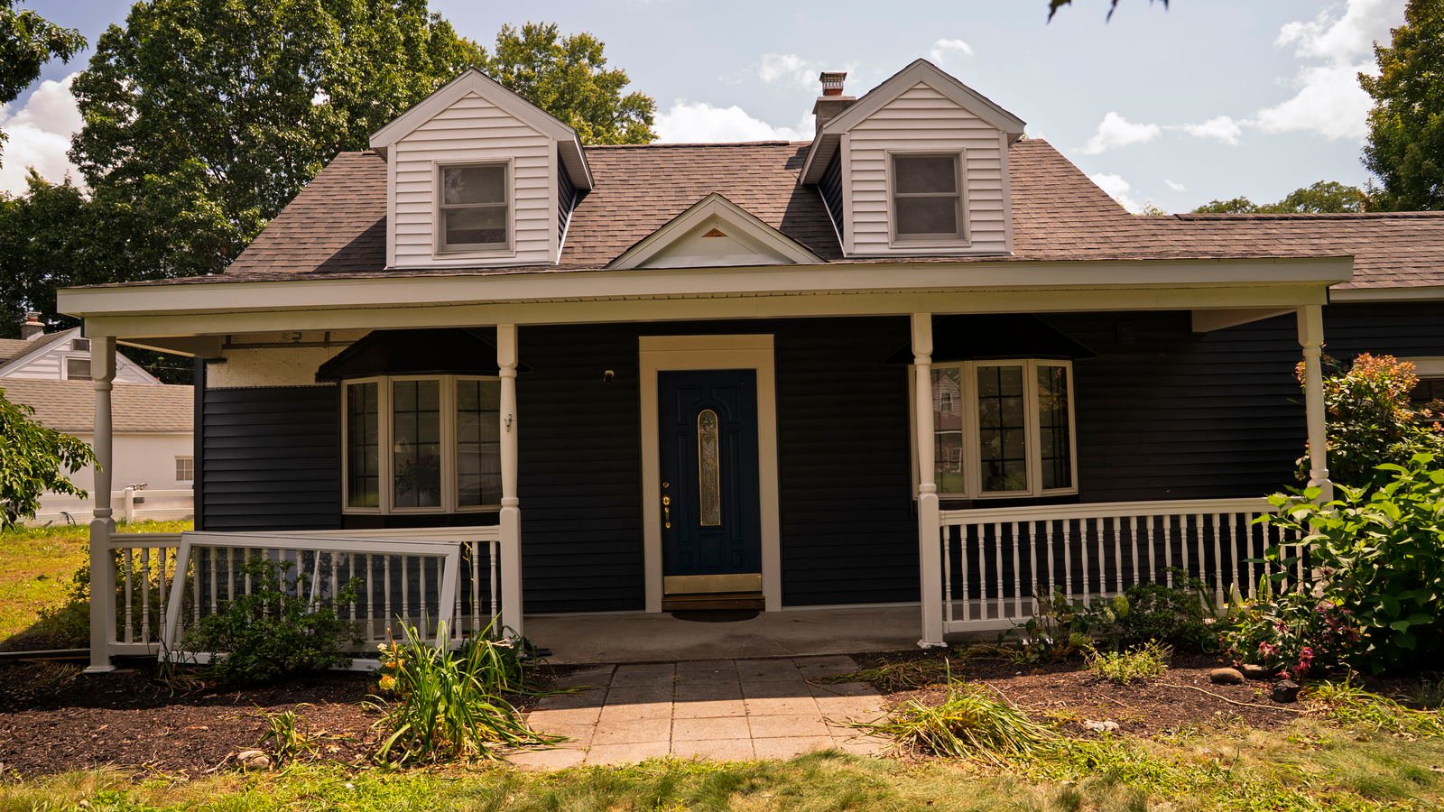 Finished navy blue vinyl siding with white trim and dormers on a Rotterdam, New York Cape Cod home